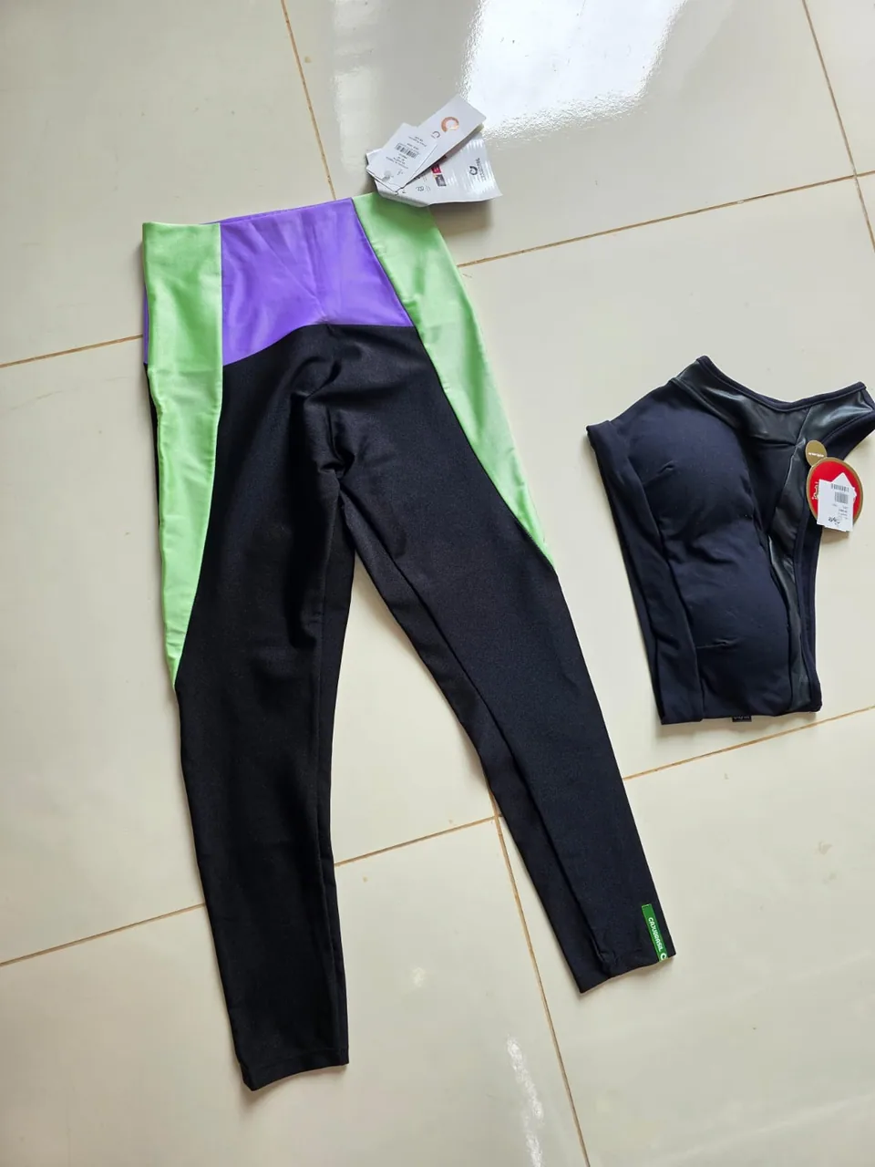 Conjunto fitness preto com recortes coloridos — Foto real, sem filtro